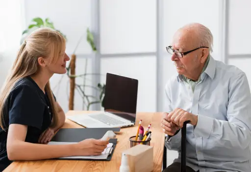 Joven trabajadora atendiendo a un señor de la 3a edad